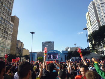 Crowd in city against clear sky