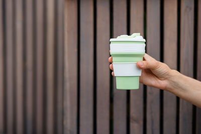 Cropped hand of man with disposable cup