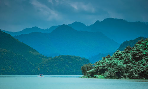 Scenic view of sea and mountains against sky