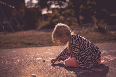 Girl drawing on the ground