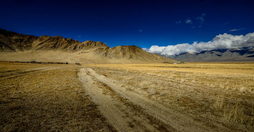 Scenic view of landscape and mountains against blue sky