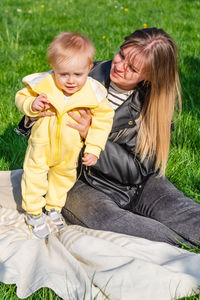 Portrait of young woman sitting on field