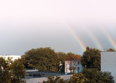Triple rainbow over buildings in city against sky