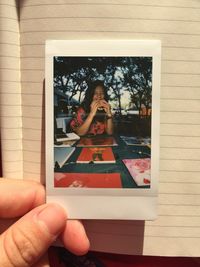 Midsection of woman photographing with reflection on table