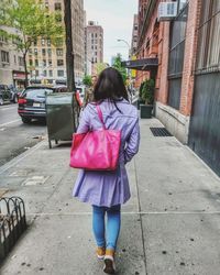 Rear view of woman walking on street in city