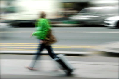 Blurred motion of people riding motorcycle on street