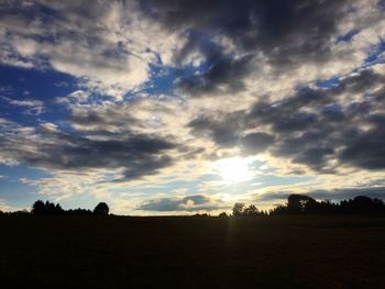 Scenic view of silhouette field against sky at sunset