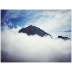 Scenic view of mountains against cloudy sky