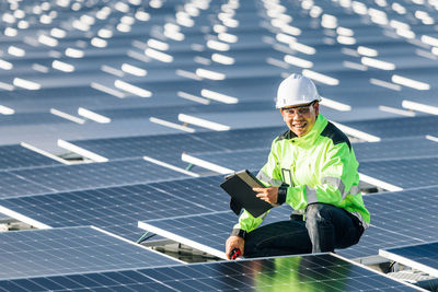 Young electrical engineer checking solar panel quality and control the electricity in the building