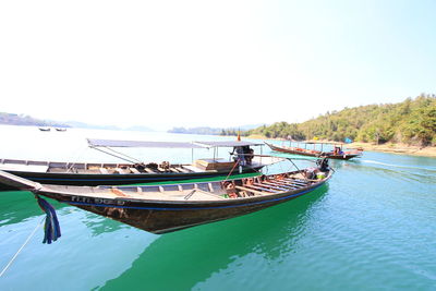 Boat moored on sea against clear sky