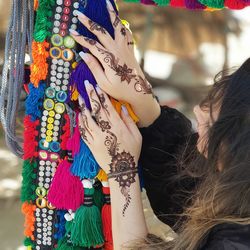 Close-up of woman hand with multi colored umbrellas for sale