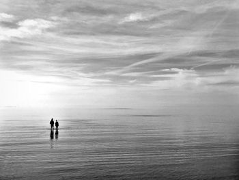 People on sea against sky