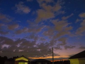 Low angle view of silhouette electricity pylon against sky during sunset