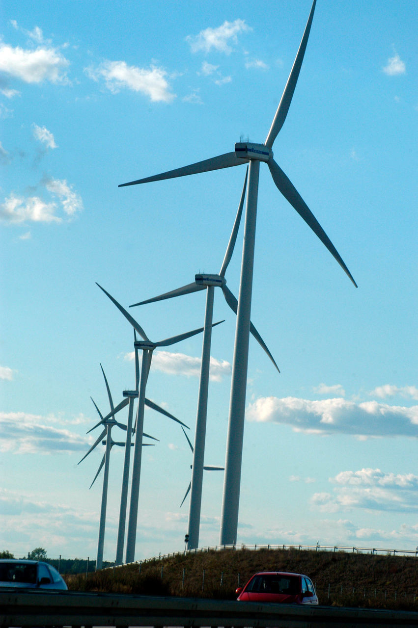 LOW ANGLE VIEW OF WIND TURBINES ON LANDSCAPE AGAINST SKY