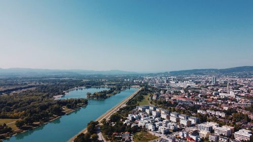 High angle view of river amidst buildings against clear sky