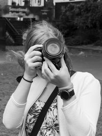 Close-up of woman photographing with camera while standing outdoors