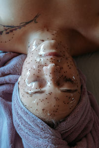 Close-up portrait of young woman applying peel off mask for facial cleansing and spa treatment.