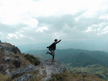 Full length of man standing on rock against sky