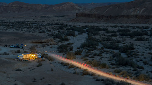 High angle view of light trails on desert road at night