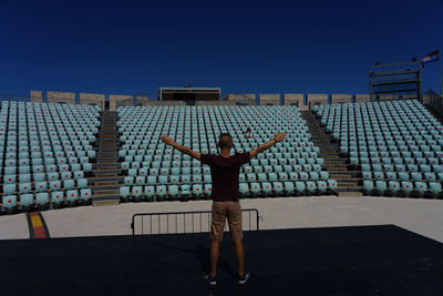Rear view of man standing against built structure
