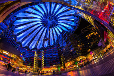 Low angle view of illuminated ferris wheel in city at night