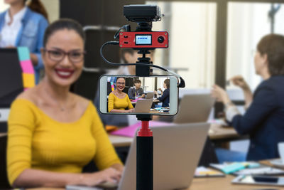 Portrait of woman holding camera