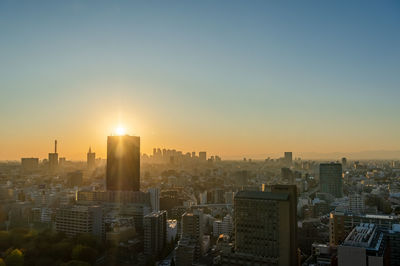 Modern buildings in city against sky during sunset