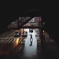 High angle view of person on zebra crossing below footbridge during rainy season