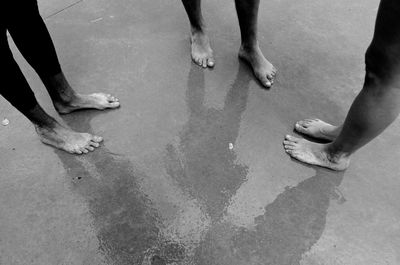 Low section of friends standing on wet walkway