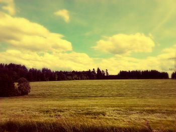 Scenic view of field against cloudy sky