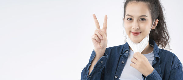 Portrait of woman standing against white background