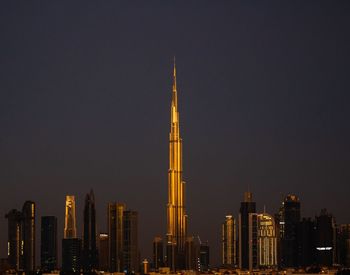 Illuminated buildings against sky at night