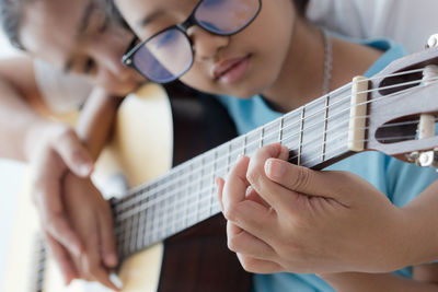 Close-up of hands playing guitar