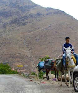 Rear view of man riding motorcycle on mountain