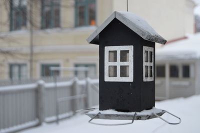 Close-up of birdhouse on building during winter