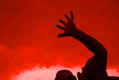 Midsection of silhouette woman against red sky during sunset