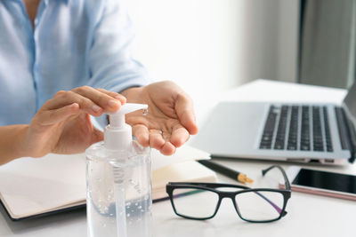 Midsection of doctor examining chemical in laboratory