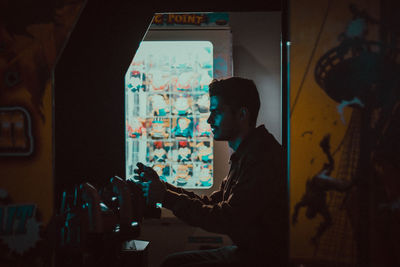 Side view of man sitting at home