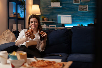 Young woman using mobile phone while sitting at restaurant