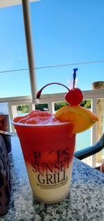 Close-up of drink on table against blue sky