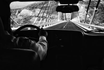 Man driving car on suspension bridge