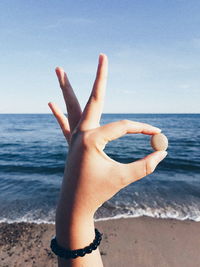 Low section of woman on beach against clear sky