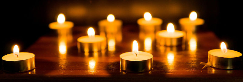 Close-up of illuminated candles on table