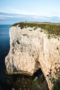 Rock formation on beach against sky