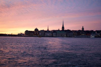 View of city at waterfront during sunset