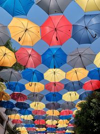 Low angle view of multi colored umbrellas against sky