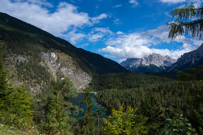 Scenic view of lake by mountains against sky