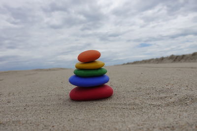 Stack of multi colored stones over an empty beach