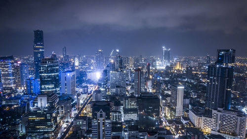 Illuminated cityscape against sky at night