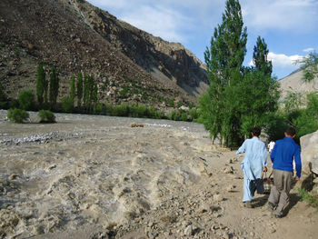 Rear view of people walking on road